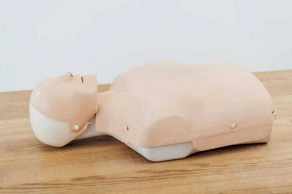Cpr dummy for first aid training on wooden table isolated on grey with copy space — Stock Photo