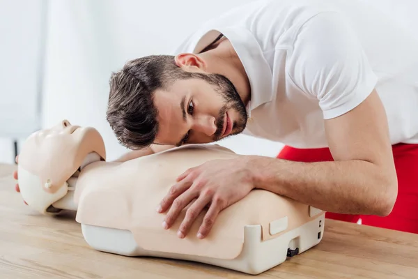 Bell'uomo che pratica la tecnica cpr sul manichino durante l'addestramento di primo soccorso — Foto stock