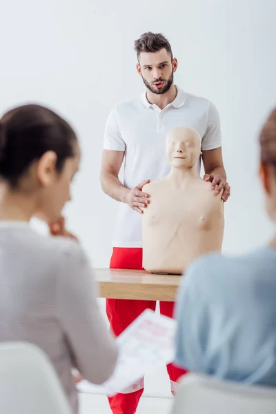 Selective focus of instructor with cpr dummy during first aid training class — Stock Photo