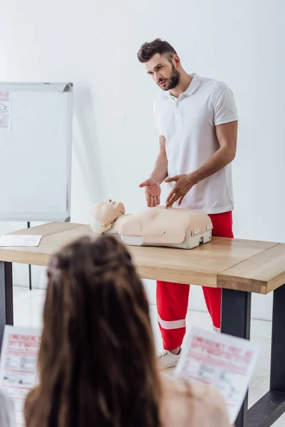 Handsome instructor gesturing with hands during first aid training class — Stock Photo