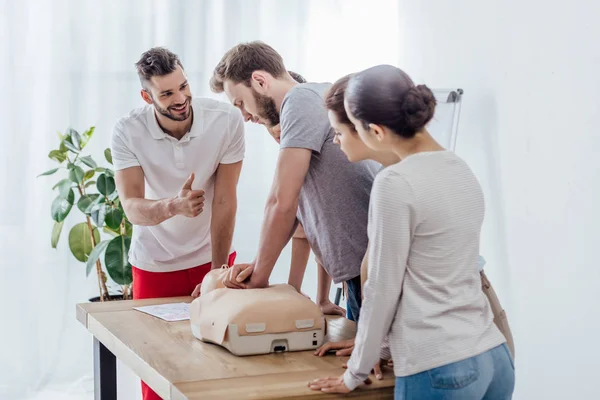 Gruppe von Personen mit CPR-Attrappe während eines Erste-Hilfe-Kurses — Stockfoto