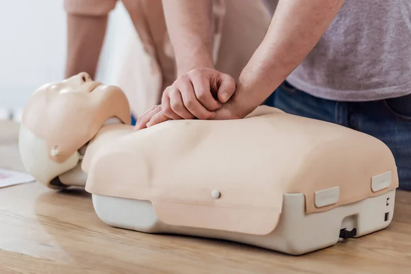 Vista parziale dell'uomo che esegue la compressione toracica sul manichino durante la lezione di formazione cpr — Foto stock