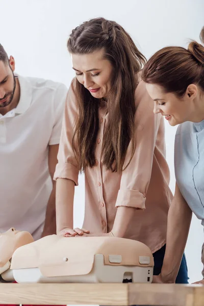 Schöne Frau, die Brustkompression auf Dummy während des CPR-Trainings durchführt — Stockfoto