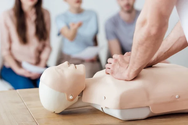 Cropped view of instructor performing chest compression on dummy during cpr training class — Stock Photo
