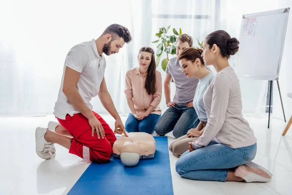 Instructor gesturing during first aid training with group of people — Stock Photo