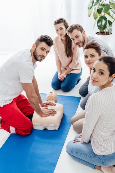 Group of people with instructor looking at camera during first aid training — Stock Photo