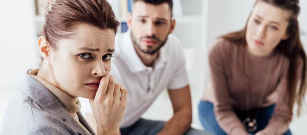 Panoramic shot of depressed woman looking at camera during group therapy session — Stock Photo