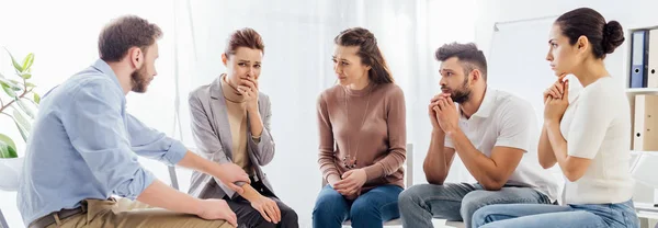 Panoramic shot of group of people sitting on chairs during therapy session — Stock Photo