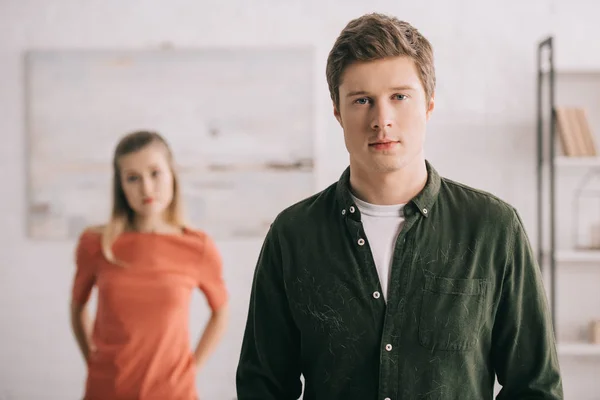 Enfoque selectivo de hombre guapo mirando a la cámara cerca de la mujer rubia - foto de stock