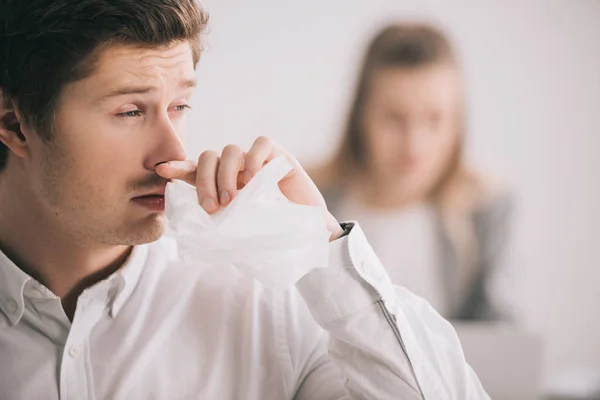 Selective focus of man having allergy in office near colleague — Stock Photo
