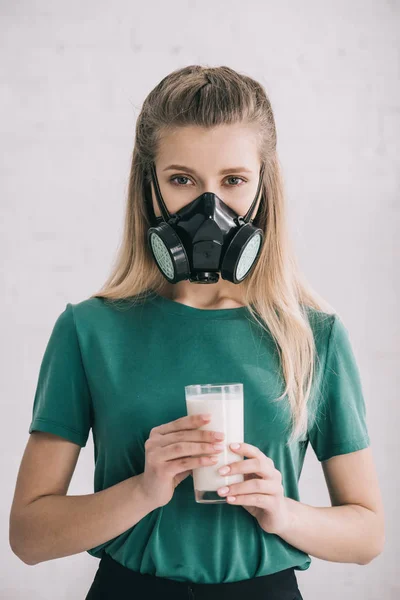 Mulher loira em máscara respiratória segurando vidro de leite — Fotografia de Stock