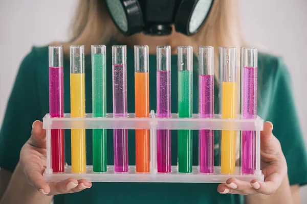 Cropped view of woman holding colorful test tubes — Stock Photo