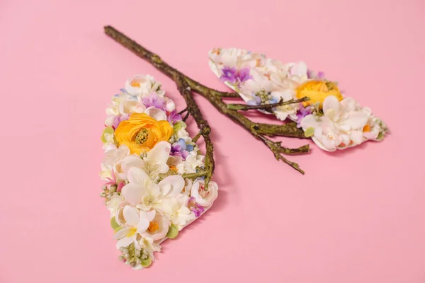 Florale Komposition mit blühenden Blüten und Zweigen in Form von Lungen auf rosa — Stockfoto