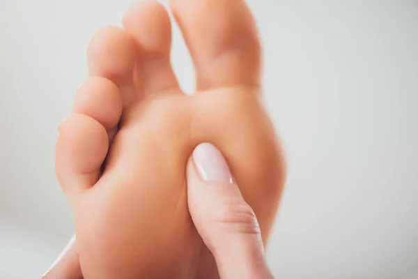 Cropped view of masseur doing foot massage to adult woman in spa — Stock Photo