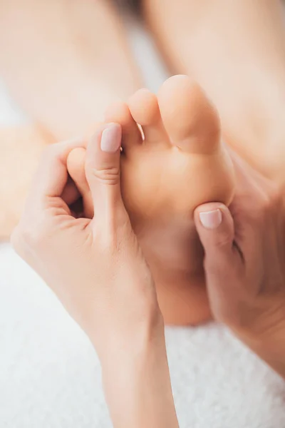 Vista cortada de massagista fazendo massagem nos pés para mulher adulta no spa — Fotografia de Stock