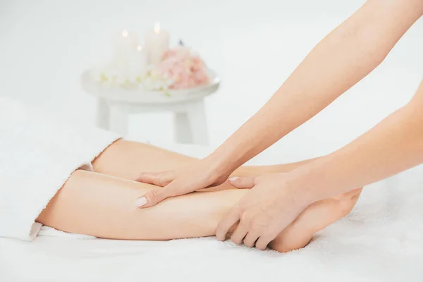 Vista recortada de masajista haciendo masaje de pies a mujer adulta en spa - foto de stock