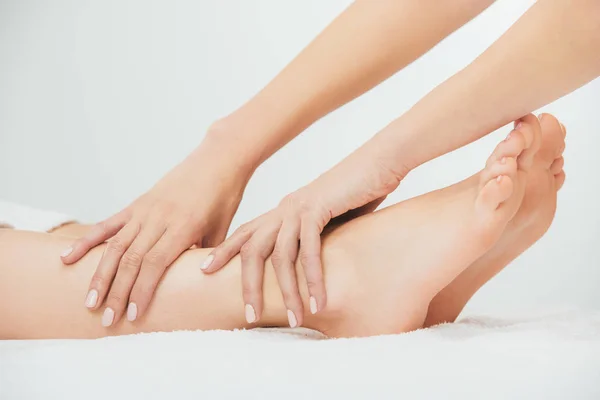 Cropped view of masseur doing foot massage to adult woman in spa — Stock Photo