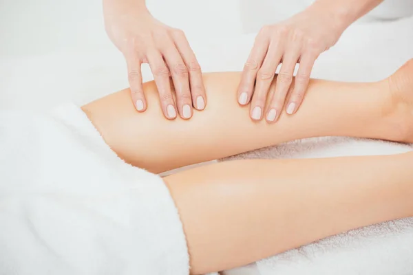 Partial view of masseur doing foot massage to adult woman in spa — Stock Photo