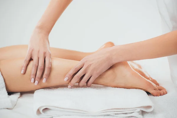 Partial view of masseur doing foot massage to adult woman in spa — Stock Photo