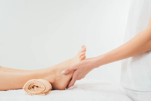 Vue partielle du masseur faisant massage des pieds à la femme adulte dans le spa — Photo de stock