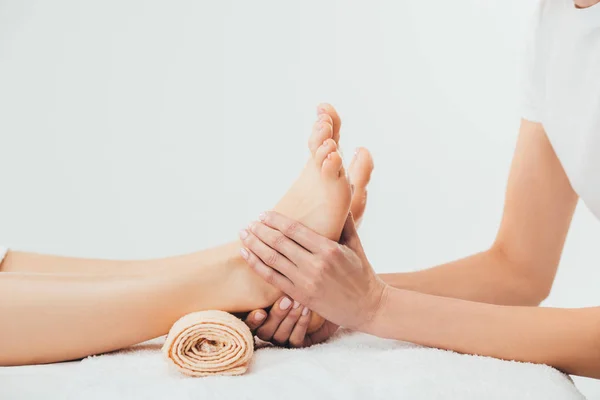 Vista parziale del massaggiatore che fa massaggio ai piedi alla donna adulta nella spa — Foto stock