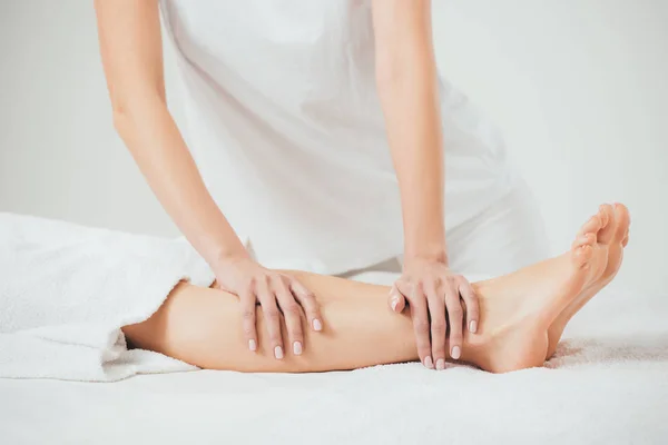 Частичный вид массажера, делающего массаж ног взрослой женщине в спа — стоковое фото