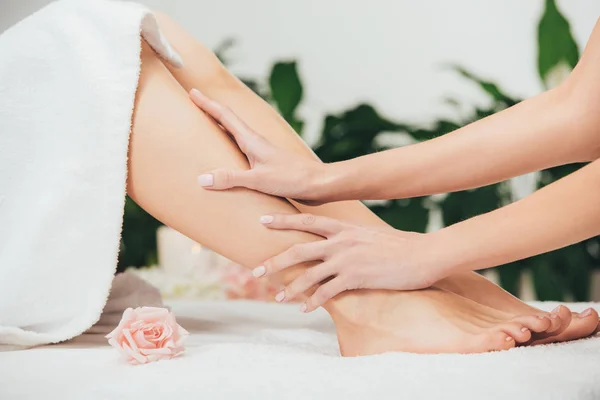 Partial view of masseur doing foot massage to adult woman in spa — Stock Photo