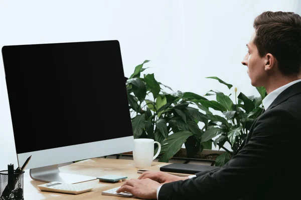 Hombre adulto en traje usando la computadora con la pantalla en blanco y espacio de copia - foto de stock