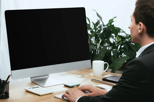 Hombre adulto en traje usando la computadora con la pantalla en blanco y espacio de copia - foto de stock