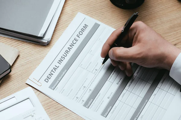 Vue recadrée de l'homme remplissant le formulaire d'assurance dentaire Dentiste Concept — Photo de stock