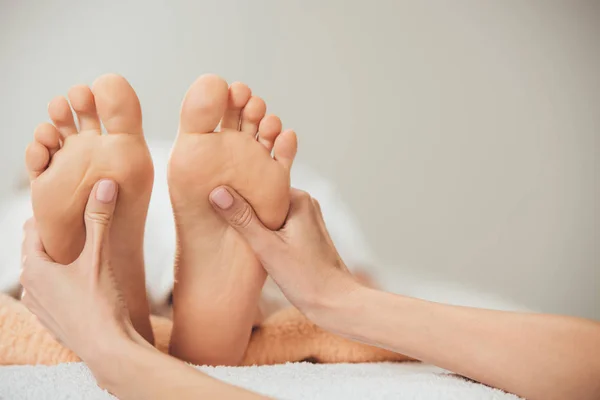 Partial view of masseur doing foot massage to adult woman in spa — Stock Photo