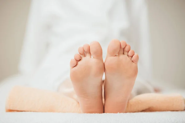 Cropped view of adult woman lying on beige towel in spa — Stock Photo