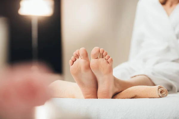 Selective focus of adult woman lying on beige towel in spa — Stock Photo