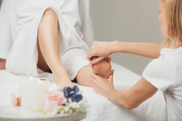 Vista cortada de massagista fazendo massagem nos pés para mulher adulta no spa — Fotografia de Stock