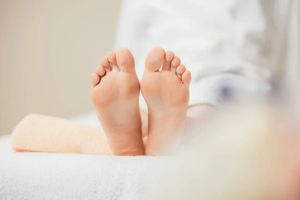 Selective focus of adult woman lying on beige towel in spa — Stock Photo