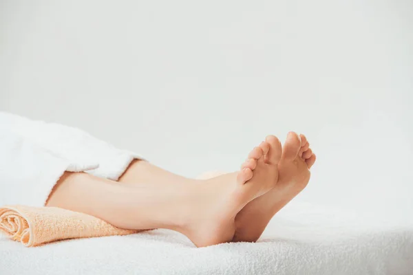 Partial view of adult woman lying on beige towel in spa — Stock Photo