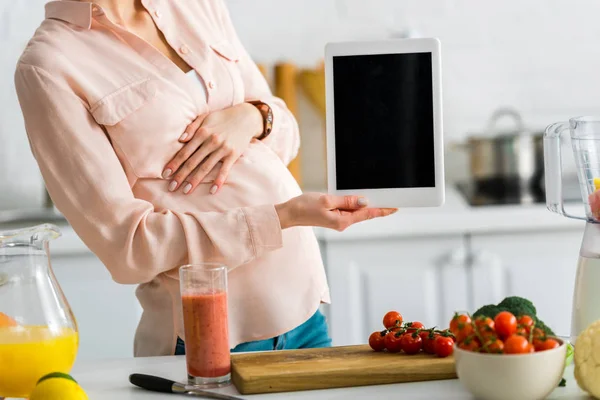 Vue recadrée de la femme enceinte tenant tablette numérique avec écran blanc — Photo de stock