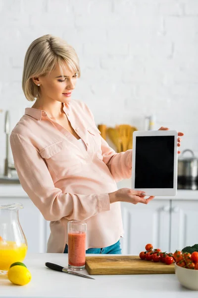 Jeune femme enceinte tenant tablette numérique avec écran blanc — Photo de stock