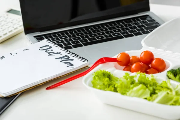 Leckeres Gemüse in der Nähe von Notizbuch mit Ernährungsplan-Schriftzug und Laptop — Stockfoto
