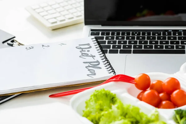 Légumes biologiques près de notebook avec plan de régime lettrage et ordinateur portable — Photo de stock