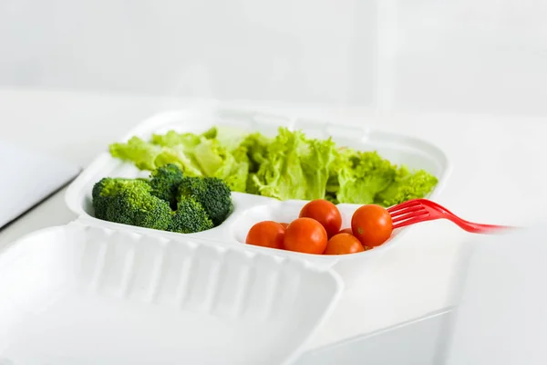 Tasty organic vegetables in take away box near plastic fork — Stock Photo