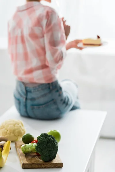 Frutta e verdura biologica vicino alla donna che tiene dolce torta — Foto stock