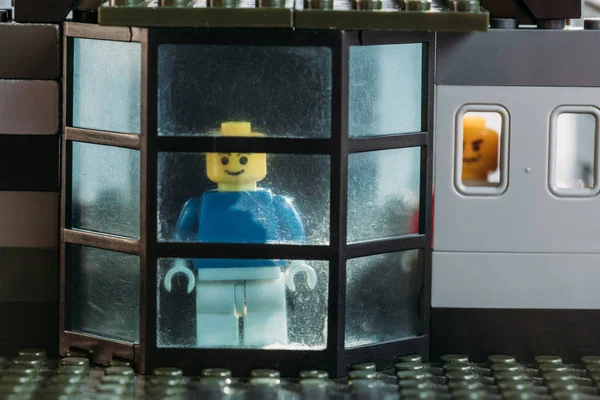 QUIIV, UCRÂNIA - MARÇO 15, 2019: figuras de lego amarelo olhando através da janela em casa de bloco — Fotografia de Stock