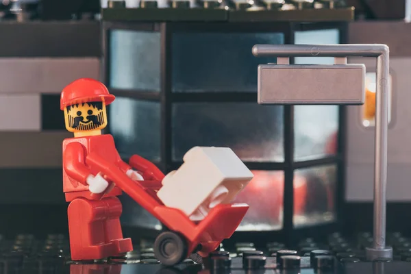 Київ, Україна-15 березня 2019: бородатий LEGO листоноша фігурка в капелюсі рухомих пакет на ручний вантажівка — Stock Photo