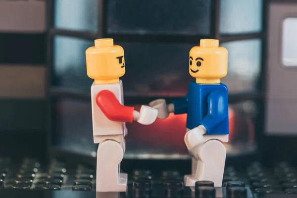 KYIV, UKRAINE - MARCH 15, 2019: yellow lego figurines with face expressions shaking hands — Stock Photo