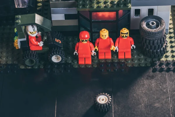 Kyiw, Ukraine - 15. März 2019: Lego-Figuren von Mechanikern in rot neben Reifen an Tankstellen — Stockfoto