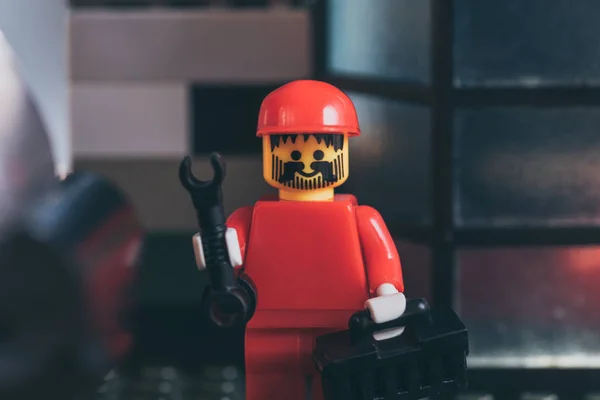 QUIIV, UCRÂNIA - MARÇO 15, 2019: close up of red lego worker figurine in hat holding wrench and tool box — Fotografia de Stock