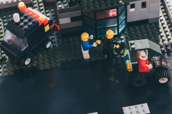 Київ, Україна-15 березня 2019: високий кут зору LEGO мініфігурки потискуючи руки, а інша фігурка їзда іграшку автомобіля — стокове фото