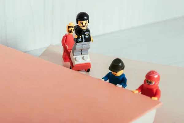 KYIV, UKRAINE - 15 MARS 2019 : figurines lego en plastique portant un livre près d'un policier — Photo de stock