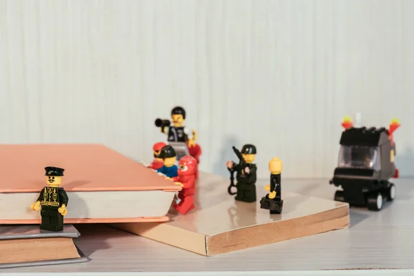 QUIIV, UCRÂNIA - MARÇO 15, 2019: minifiguras de plástico lego carregando livro perto de figuras de guarda com arma e bocal — Fotografia de Stock